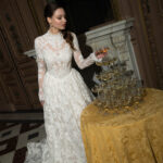 Fabric is Sheet lace, silhouette is Fitted jacket overlay, neckline is High neck, sleeve style is Long sleeves, train is None (overlay jacket only), waistline is Natural, fitted to gown, embellishment is Intricate lace appliqué, back is Sheer illusion with button closure, color is Ivory/Nude, style is Regal, Vintage-inspired, Detachable, versatile for ceremony-to-reception transformation