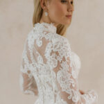 Fabric is Sheet lace, silhouette is Fitted jacket overlay, neckline is High neck, sleeve style is Long sleeves, train is None (overlay jacket only), waistline is Natural, fitted to gown, embellishment is Intricate lace appliqué, back is Sheer illusion with button closure, color is Ivory/Nude, style is Regal, Vintage-inspired, Detachable, versatile for ceremony-to-reception transformation