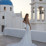 Fabric is Crepe & Lace, silhouette is Sheath, neckline is Illusion Plunge, sleeve style is Spaghetti Straps, train is Chapel with Lace Appliqué, waistline is Natural, embellishment is Floral Lace Appliqué, back is Illusion Low Back, color is Ivory/Nude, style is Modern Romantic, Sheer bodice, Button-back detailing, Lightweight crepe skirt