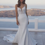 Fabric is Crepe & Lace, silhouette is Sheath, neckline is Illusion Plunge, sleeve style is Spaghetti Straps, train is Chapel with Lace Appliqué, waistline is Natural, embellishment is Floral Lace Appliqué, back is Illusion Low Back, color is Ivory/Nude, style is Modern Romantic, Sheer bodice, Button-back detailing, Lightweight crepe skirt
