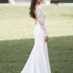 Fabric is Crepe & Lace, silhouette is Sheath, neckline is High Neckline, sleeve style is Long Lace, train is Sweep Train, waistline is Natural, embellishment is Lace Appliqué, back is Low Scoop, color is Ivory/Nude, style is Minimalist Elegance, Buttons down the back