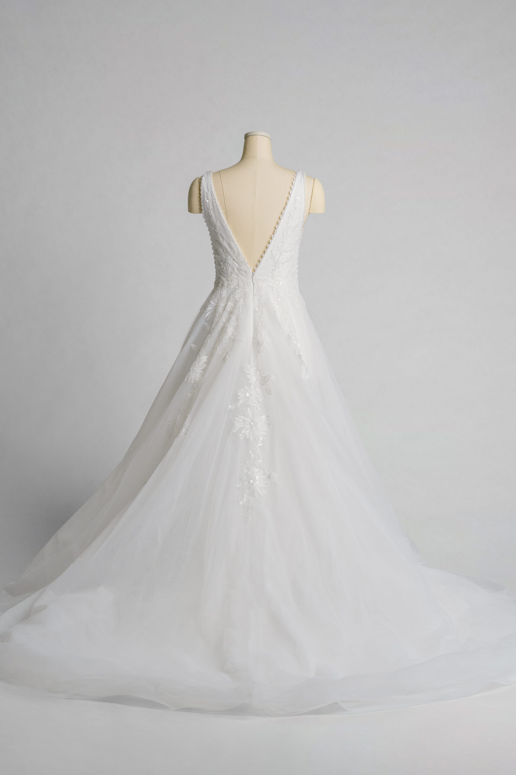 Fabric is Tulle & Lace, silhouette is A-Line, neckline is Deep V-Neck, sleeve style is Sleeveless, train is Chapel Train, waistline is Natural Waist, embellishment is Floral Appliqué, Beading, back is Deep V-Back, color is Soft Ivory, style is Romantic Elegance, Illusion Bodice, Sheer Detailing
