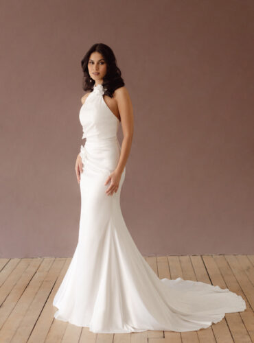 Fabric is Satin, silhouette is Fit and Flare / Modified A-Line, neckline is Halter, sleeve style is Sleeveless, train is Chapel Train, waistline is Natural Ruched, embellishment is 3D Floral Appliqué, back is Low V-Back, color is Ivory, style is Modern Minimalist Romance, Smooth satin with 3D floral details and a removable train for two distinct bridal looks.