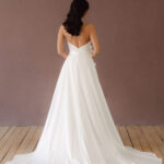 Fabric is Satin, silhouette is Fit and Flare / Modified A-Line, neckline is Halter, sleeve style is Sleeveless, train is Chapel Train, waistline is Natural Ruched, embellishment is 3D Floral Appliqué, back is Low V-Back, color is Ivory, style is Modern Minimalist Romance, Smooth satin with 3D floral details and a removable train for two distinct bridal looks.