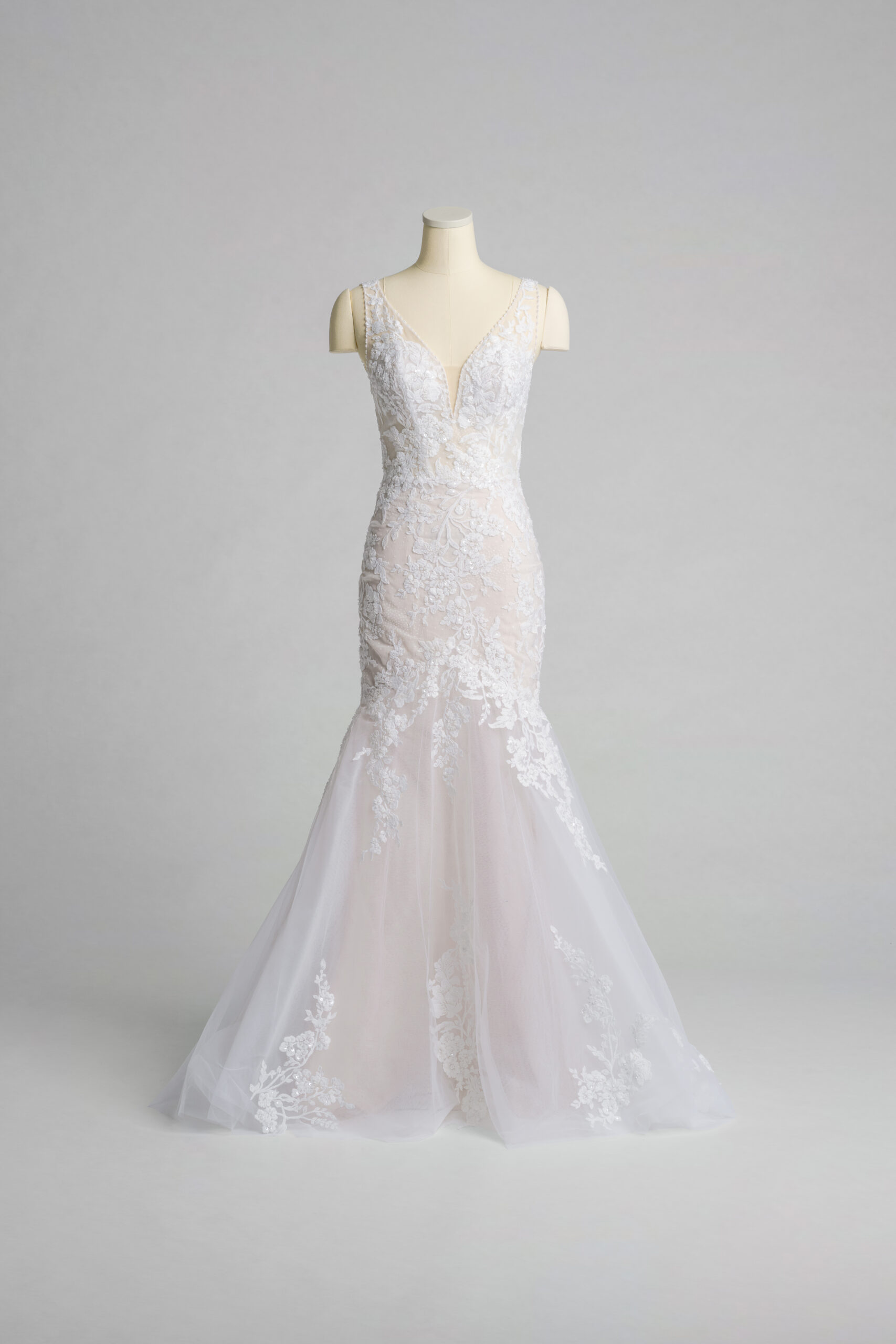 Fabric is Tulle & Lace, silhouette is Mermaid, neckline is Plunge V-neck, sleeve style is Sleeveless, train is Chapel, waistline is Natural, embellishment is Floral Lace Appliqué, back is Low Scoop, color is Ivory/Nude, style is Sexy Glam, Illusion bodice, fitted through hips, romantic floral detail