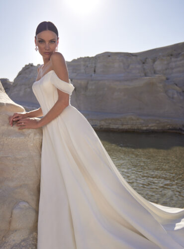 Fabric is Satin & Chiffon, silhouette is A-line, neckline is Cat eye neckline, sleeve style is Off-the-shoulder, train is Chapel, waistline is Basque, embellishment is Covered buttons, back is Button-up back, color is Ivory, style is Minimalist Romance, Boned bodice, soft drape