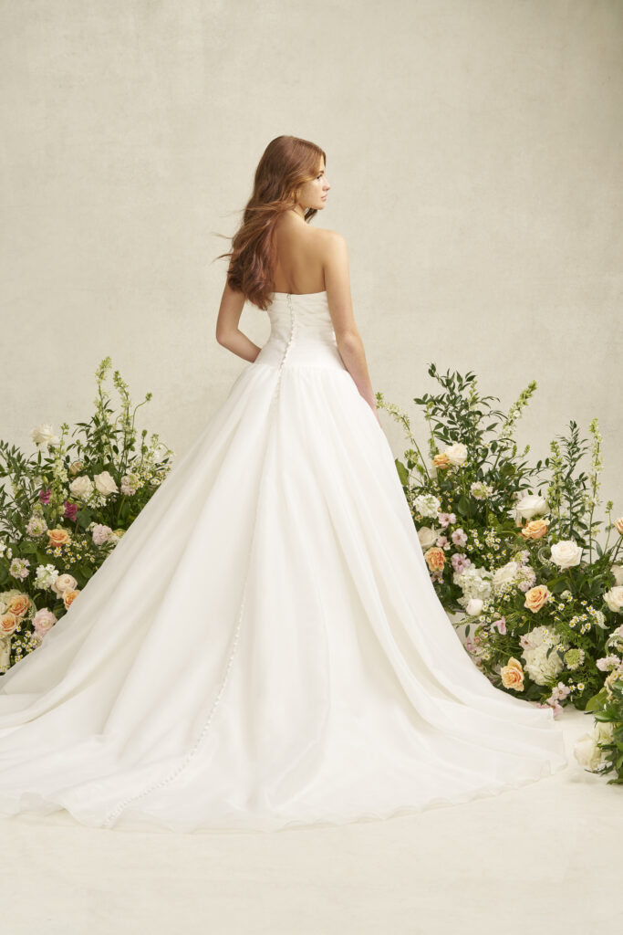 Fabric is Satin & Organza, silhouette is A-line, neckline is Scoop, sleeve style is Strapless, train is Chapel, waistline is Dropped, embellishment is Ruched Bodice, back is Covered Buttons, color is Ivory, style is Romantic Minimalism, Softly structured skirt