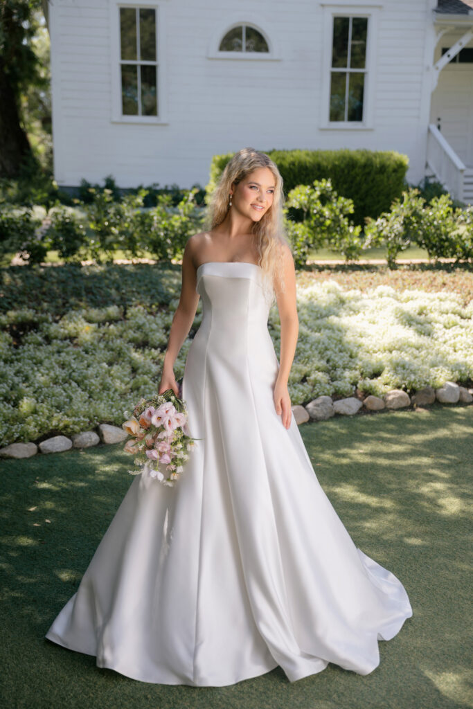 Fabric is Mikado, silhouette is A-line, neckline is Rolled strapless, sleeve style is Strapless, train is Chapel, waistline is Natural, embellishment is Minimalist, structured, back is Lace-up corset, color is Ivory, style is Modern classic, Clean lines, elegant tailoring