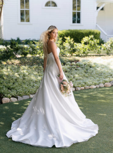 Fabric is Mikado, silhouette is A-line, neckline is Rolled strapless, sleeve style is Strapless, train is Chapel, waistline is Natural, embellishment is Minimalist, structured, back is Lace-up corset, color is Ivory, style is Modern classic, Clean lines, elegant tailoring