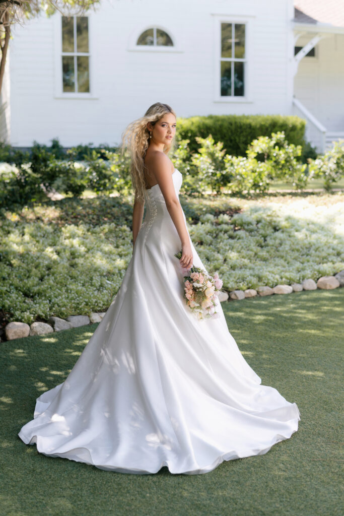 Fabric is Mikado, silhouette is A-line, neckline is Rolled strapless, sleeve style is Strapless, train is Chapel, waistline is Natural, embellishment is Minimalist, structured, back is Lace-up corset, color is Ivory, style is Modern classic, Clean lines, elegant tailoring