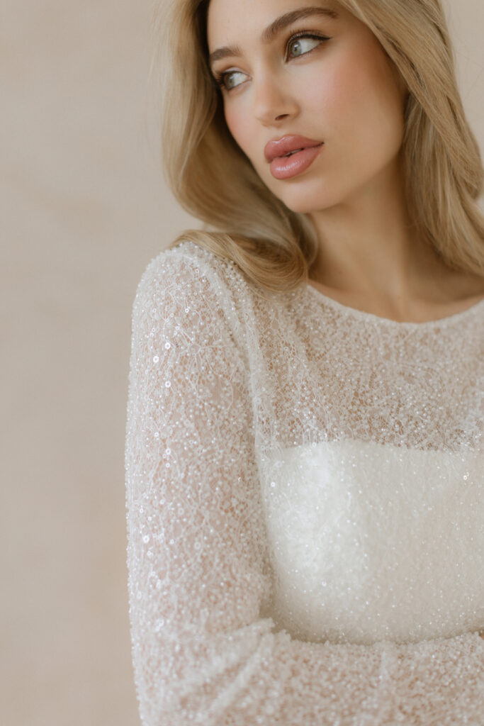 Fabric is Beaded lace / Sequin lace, silhouette is Fitted jacket, neckline is Bateau, sleeve style is Long sleeves, train is None, waistline is Natural, embellishment is Beading / Sequins, back is Buttoned back, color is Ivory, style is Classic elegance, Sheer overlay / Bridal jacket