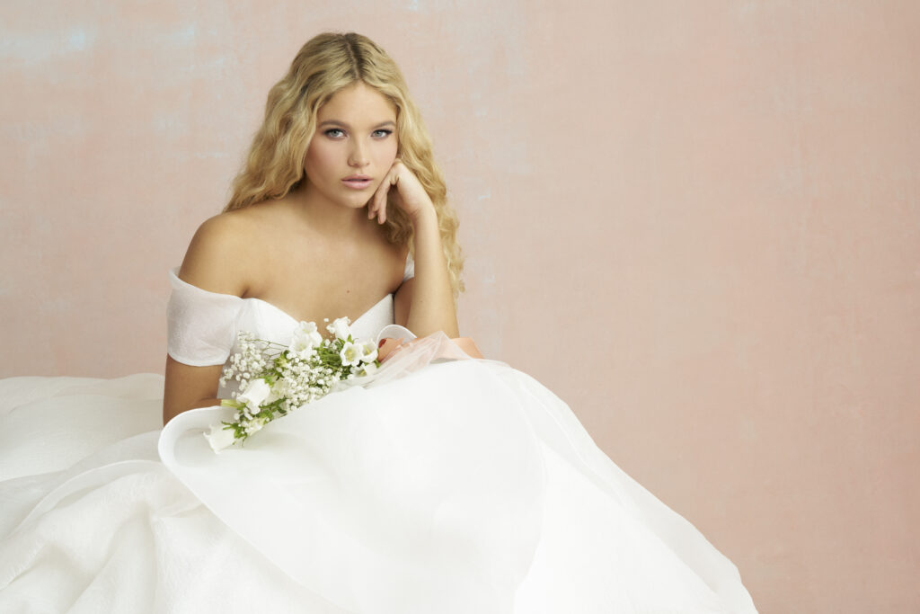 Fabric is Crushed organza, silhouette is Ballgown, neckline is Sweetheart, sleeve style is Off-shoulder, train is Chapel, waistline is Natural, embellishment is Layered skirt, back is V-back, color is Ivory, style is Romantic classic, Handkerchief hem