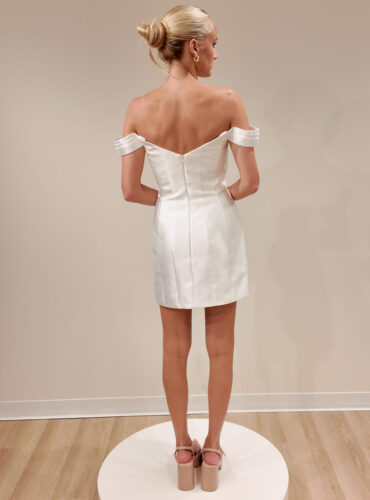 Fabric is Satin, silhouette is Sheath Mini, neckline is Sweetheart, sleeve style is Off-Shoulder, train is No Train, waistline is Natural, embellishment is Minimalist, back is Zip Back, color is Ivory, style is Modern Minimalist, Structured seams, short bridal dress, clean lines